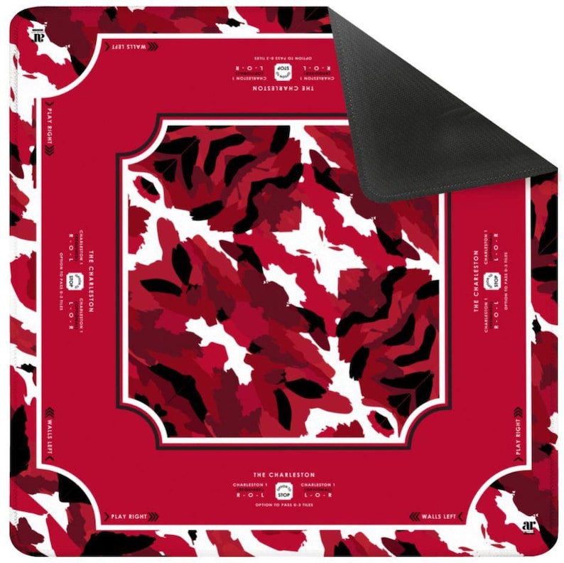 May include: A square Mahjong mat featuring a red, white, and black camouflage-style pattern in the center. The border is solid red with white text reading THE CHARLESTON, instructions for passing tiles, and directional arrows for play.