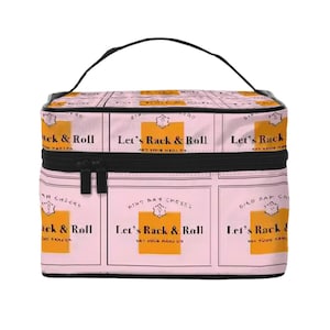 May include: Pink cosmetic bag with a black handle and zipper. The bag features a repeating pattern of champagne bottle labels with the text "Let's Rack & Roll" in black and gold.