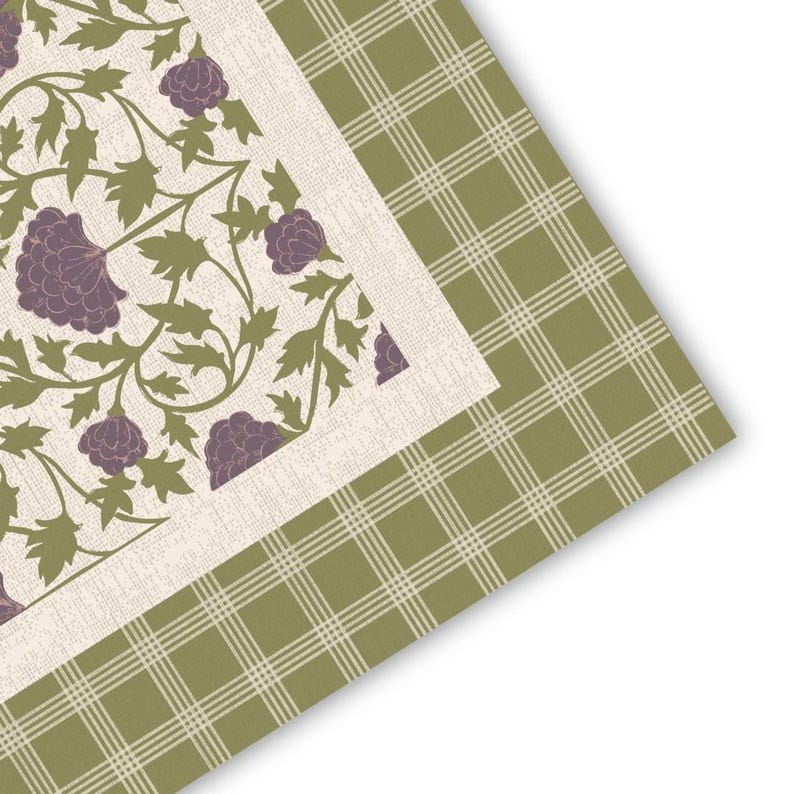 May include: A textile piece featuring a central panel with a cream background, decorated with a repeating pattern of purple flowers and olive green leaves. This central section is framed by a border of olive green fabric with a white plaid pattern.