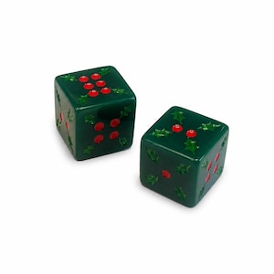 May include: Two dark green six-sided dice featuring a holly berry and leaf pattern. The pips on the dice are represented by small, bright red circular berries, while green holly leaves are embossed around the red berry clusters on each face.