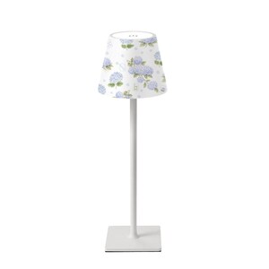 K&ouml;nnte beinhalten: Eine wei&szlig;e Tischlampe mit quadratischem Fu&szlig; und schlankem Stiel. Der Lampenschirm ist wei&szlig; und mit einem Muster aus blauen und violetten Hortensienbl&uuml;ten verziert. Die Lampe ist f&uuml;r den Innenbereich konzipiert.