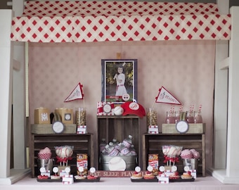 May include: A baseball-themed party table setting with red and white checkered canopy, wooden crates, and a variety of treats, including cupcakes, popcorn, and drinks. The table is decorated with baseball-themed decorations, including baseballs, bats, and pennants. The table also features a sign that reads "Eat, Sleep, Play All".