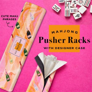 May include: Mahjong pusher racks with a designer case. The case has a pink and orange striped pattern with champagne bottle illustrations. The text "Let's Rack & Roll" is visible on the case. The image also shows mahjong tiles.