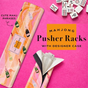 May include: Mahjong pusher racks with a designer case. The case has a pink and orange striped pattern with champagne bottle illustrations. The text "Let's Rack & Roll" is visible on the case. The image also shows mahjong tiles.