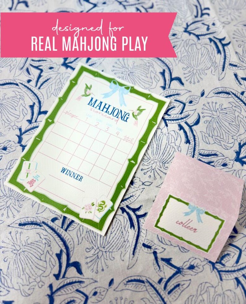 May include: A Mahjong scorecard and a pink name tag with the name "colleen" are displayed on a floral patterned surface. The scorecard has a green bamboo-style border and the text "designed for REAL MAHJONG PLAY".