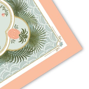 May include: A decorative print featuring a light blue background with a repeating floral pattern. The design includes a gold-bordered oval with a pink pineapple and green palm fronds. The print is framed with a peach-colored border.