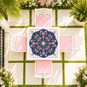 May include: Overhead view of a white outdoor dining set with four chairs and a square table. The table has a navy blue floral design in the center, surrounded by a pink and white striped border. The chairs have white frames and pink cushions.