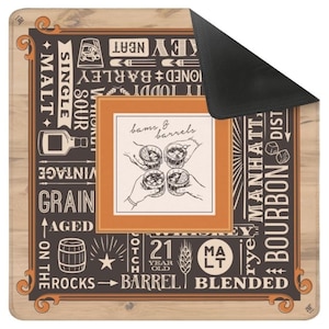 May include: A square, brown and black bar mat with a vintage whiskey theme. The mat features text and illustrations related to whiskey, including "Malt," "Bourbon," and "Barrel." The center has an illustration of hands holding whiskey glasses.