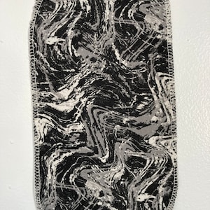 May include: A black and white marbled fabric patch with a white stitched border.