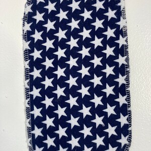 May include: A blue fabric square with white stars printed on it. The fabric is sewn around the edges.