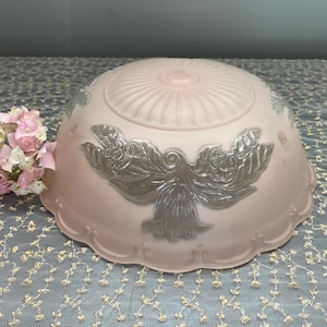 May include: A pink glass ceiling light fixture with a silver floral design. The fixture has a scalloped edge and a ribbed top.