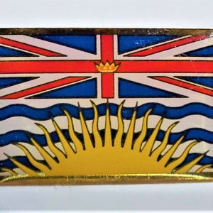 Puede incluir: Pin rectangular con la bandera de la Columbia Británica, Canadá. El diseño incluye la Union Jack, una corona, un patrón ondulado azul y blanco y un sol amarillo con rayos. El pin tiene un borde dorado.