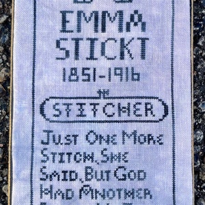 May include: A framed cross-stitch sampler with a purple background and black embroidery. The sampler reads "Emma Stickt 1851-1916 (Stitcher) Just one more stitch, she said, but God had another plan & He took her to glory with a needle in her hand."
