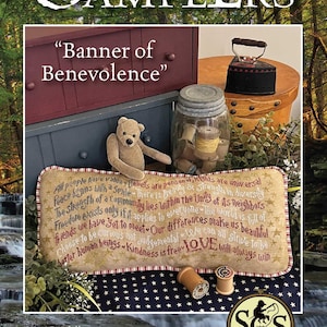 May include: A decorative pillow with the text "Banner of Benevolence" and inspirational quotes. The pillow is beige with red and blue accents, and is surrounded by vintage items like a teddy bear, jar, and iron.