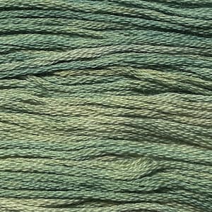 May include: Close-up of a skein of variegated embroidery floss. The thread is a blend of muted greens and beige, creating a textured, natural appearance. The strands are tightly wound, suggesting a durable and high-quality material, ideal for various needlecraft projects.