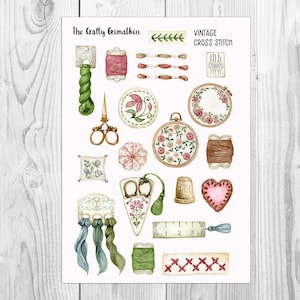 May include: Watercolor illustration of vintage cross stitch supplies. The image includes embroidery hoops, scissors, thread spools, needles, thimble, and a heart-shaped pincushion. The text "The Crafty Grimalkin" and "Vintage Cross Stitch" are visible.