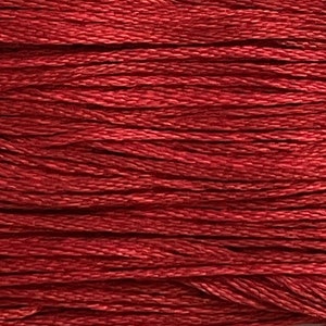May include: A close-up of a spool of red embroidery floss. The floss is tightly wound and has a smooth, shiny finish.