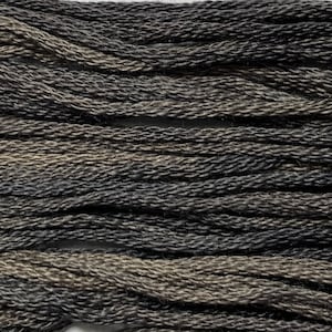 May include: Close-up of a bundle of dark gray and brown yarn. The yarn is tightly twisted, with a textured appearance. The colors blend together, creating a mottled effect. Ideal for knitting, crochet, or other fiber crafts.