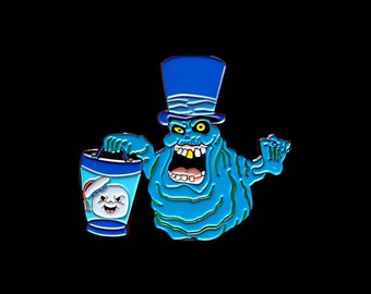 Puede incluir: Un pin de esmalte azul y blanco con un fantasma que lleva un sombrero de copa y sostiene un recipiente azul y blanco con una cara de fantasma. El fantasma tiene una sonrisa de dientes y lleva un sombrero de copa azul.