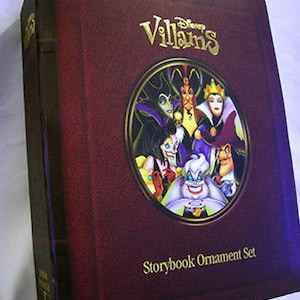 Könnte beinhalten: Ein kastanienbraunes Disney Villains Storybook Ornament Set. Der Einband zeigt eine goldgerahmte Illustration verschiedener Disney-Bösewichte. Die Worte "Disney Villains" stehen in goldener Schrift über der Illustration. Darunter steht "Storybook Ornament Set".