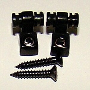 May include: Two black metal guitar string tree saddles with two black screws.