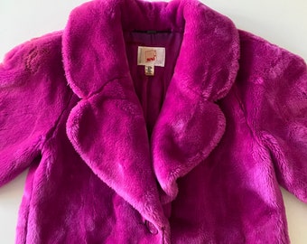 May include: A purple faux fur jacket with a large collar and a button closure. The jacket has a label that says "M.M.LaFleur".