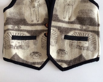 May include: A cream-colored vest with a black trim and a brown patterned design. The vest has two pockets on the front and a button closure.