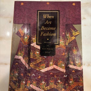 May include: A book titled "When Art Became Fashion" with a burgundy cover featuring a kimono design. The cover has gold accents and the text "Kosode in Edo-Period Japan". The book is a historical reference.