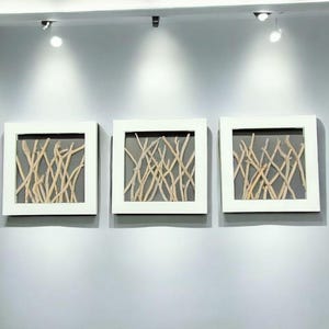May include: Three white framed wall art pieces with a gray background and a design of natural driftwood branches.