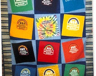May include: A quilt made from blue denim squares with various colored squares featuring the Sheridan Elementary School logo. The logo features a rainbow arch with three children standing under it. The quilt also features a yellow square with a tie-dye pattern and a blue square with the word "LEADING" printed on it.