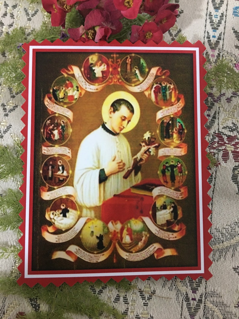 Puede incluir: Una imagen religiosa colorida de un joven en una t&uacute;nica blanca sosteniendo una cruz. La imagen est&aacute; rodeada por un c&iacute;rculo de im&aacute;genes m&aacute;s peque&ntilde;as que representan escenas de la vida del joven. La imagen est&aacute; enmarcada en un borde rojo y blanco.