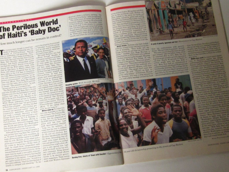 May include: A black and white photo of a man in a suit standing with a group of people. The man is smiling and the people are looking at the camera. The photo is taken in a street setting. The caption reads "The Perilous World of Haiti's 'Baby Doc' How much longer can he remain in control?"