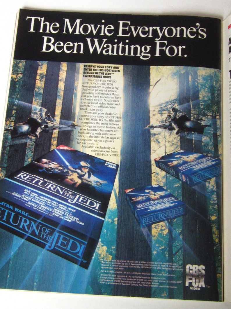 May include: A vintage advertisement for the movie "Star Wars: Return of the Jedi" on VHS. The ad features a blue and green forest background with a close-up of the VHS tape cover. The text on the ad reads "The Movie Everyone's Been Waiting For." and "Reserve Your Copy and Enter the CBS/FOX Video Return of the Jedi Sweepstakes Now!"