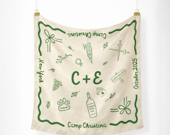 May include: Cream-colored bandana with green illustrations and text. Features a border design and the words "Camp Christina," "New York," and "October 2025." Includes drawings of a flower, lizard, wine bottle, and playing cards.