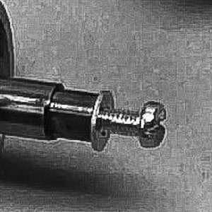May include: A close-up of a silver metal bolt with a hexagonal nut. The bolt is threaded and has a smooth, polished finish.