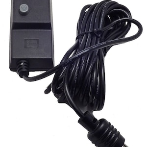 May include: A black remote control with two buttons and a black cord with a three-prong plug.