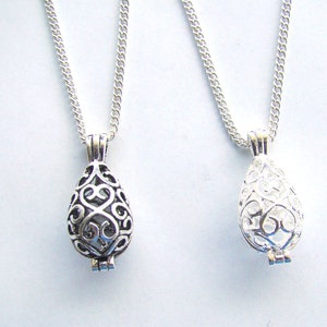 May include: Two silver necklaces with delicate chain links and a teardrop-shaped pendant. The pendant is an openwork design with a filigree pattern.