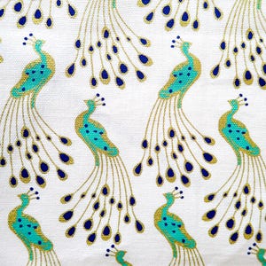 May include: White fabric with a repeating pattern of stylized peacocks. The peacocks feature teal bodies, gold accents, and navy blue tail feathers. The design is a repeating pattern across the fabric.