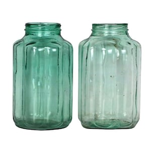 Peut inclure: Deux bocaux en verre transparent vert avec un motif cannelé. Les bocaux sont vides et ont un aspect vintage.