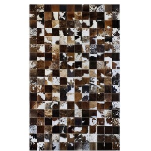 May include: A patchwork rug made of cowhide squares in various shades of brown, black, and white. The rug has a chequered pattern.