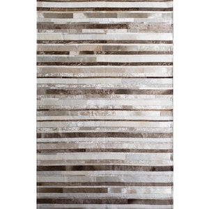 May include: Rectangular rug with a patchwork design. The rug features horizontal stripes in shades of brown, beige, and silver. The texture appears to be a mix of materials, creating a visually interesting surface. Suitable for living rooms or bedrooms.