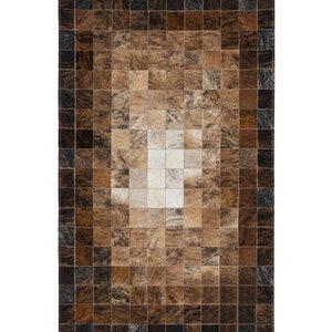 Puede incluir: Una alfombra de piel de vaca patchwork marrón y blanca con un patrón cuadrado. La alfombra tiene un borde marrón oscuro.