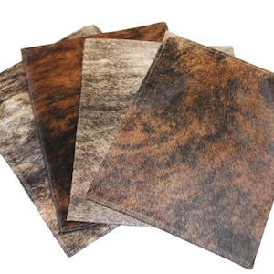 May include: Four cowhide placemats in brown, black, and white with a mottled pattern.