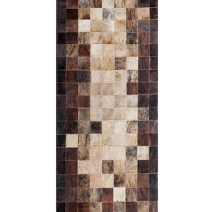 Könnte beinhalten: Ein brauner und weißer Patchwork-Teppich aus Kuhfell. Der Teppich besteht aus Quadraten unterschiedlicher Größe und Farbe.