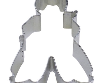 May include: A silver metal cookie cutter shaped like a person wearing a cowboy hat and pants.