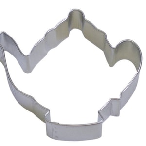 May include: A silver metal cookie cutter shaped like a teapot.