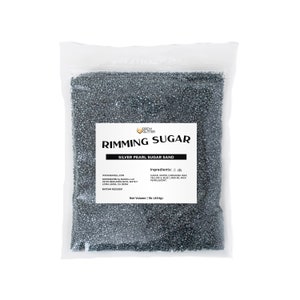 May include: A clear plastic bag containing silver pearl sugar sand for rimming cocktails. The bag features a label that reads "Rimming Sugar" and "Silver Pearl Sugar Sand". The label also lists the ingredients: sugar, water, carnauba wax, yellow 5 lake, blue 1 lake, red 40 lake, and mica pearlescent. The net volume is 1 lb (454g).