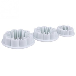 May include: Three white plastic flower cookie cutters of different sizes.