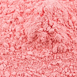 May include: Close-up of a pile of fine, pink powder. The powder has a slightly grainy texture and is evenly distributed.