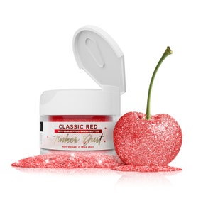 May include: A small jar of red edible glitter labeled "Classic Red" and "Tinker Dust" with a net weight of 0.18oz (5g). A red glitter-covered cherry sits next to the jar.